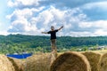 Boy jumping on round straw bales