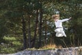 Boy jumping from sand dunes in pinewood forest