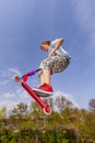 Boy is jumping with a scooter over a spine in the skate parc