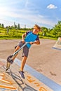 Boy is jumping with scooter in a skatepark