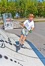 Boy is jumping with scooter in a skatepark