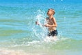 A little boy playing in the sea water. A child jumps from the sea. A tropical vacation with children. Royalty Free Stock Photo