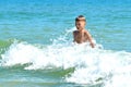 A little boy playing in the sea water. A child jumps from the sea. A tropical vacation with children. Royalty Free Stock Photo