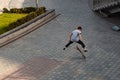 Boy jumping on skateboard at the street. Funny kid skater practicing ollie on skateboard at sunset. Royalty Free Stock Photo