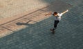 Boy jumping on skateboard at the street. Funny kid skater practicing ollie on skateboard at sunset. Royalty Free Stock Photo