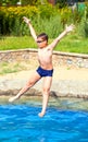 Boy jumping into a swimming pool Royalty Free Stock Photo