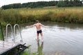 Boy jumping from wooden bridge into pond Royalty Free Stock Photo