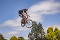 Boy jumps with his dirt bike over the ramp at an artificial trial