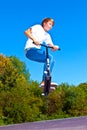 Boy jumps with his trick scooter in the skatepark Royalty Free Stock Photo