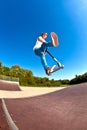 Boy jumps with his trick scooter in the skatepark Royalty Free Stock Photo