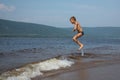 The boy jumps over the waves on the beach.Sunny summer day