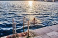 The boy jumps into the sea from a stone pier at sunset Royalty Free Stock Photo