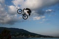 Boy jumps into sea whith bicycle extreme sport background sunset sky wispy clouds original summer