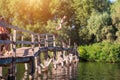 The boy jumps from a wooden bridge into the water