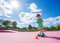 Boy on the kick scooter ride around orange cones at skate park