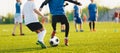 Boy kicking soccer ball. Close up action of boys soccer teams, aged 8-10, playing a football match Royalty Free Stock Photo