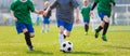 Boy Kicking Soccer Ball. Running Soccer Football Players. Five Junior Footballers on Duel. Football Grass Field and Soccer Stadium Royalty Free Stock Photo