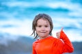 Boy kid on the beach on summer holidays. Child in nature with beautiful sea show thumb up, like or yes gesture. Happy Royalty Free Stock Photo