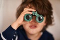 Boy, kid and binocular with toys and playing, closeup of fun and innocent with search or surveillance. Investigate Royalty Free Stock Photo