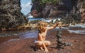 Boy kid building stone stack on pebble beach. Royalty Free Stock Photo