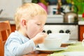 Boy kid child eating corn flakes breakfast morning meal at home.