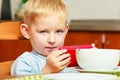 Boy kid child eating corn flakes breakfast playing mobile phone Royalty Free Stock Photo