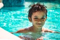 Boy kid child eight years old inside swimming pool portrait happy fun bright day.