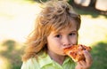 Boy kid enjoy eating pizza. Eatiing pizza outdoor. Royalty Free Stock Photo