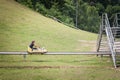 Boy, a kid, going down a slope of Straza Bled with a bobsled on a summer toboggan, in the Julian Alps, It is a major mountain