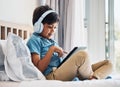 Boy, kid and headphones with tablet on bed for online games, watching movies or play educational app. Happy child Royalty Free Stock Photo