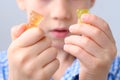 Boy, kid holding sweets in his hands, gummy bear, concept of children`s delicacy, healthy and unhealthy food, halal food Royalty Free Stock Photo