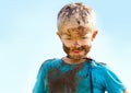 Boy, kid and mud on face with smile from playing, dirt or happiness in summer weather or water. Child, person and