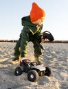 Boy kid playing radio control car riding on sand outdoor enjoying happy childhood Royalty Free Stock Photo