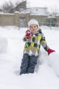 Boy kid playing in the snow. Baby playing with snow in winter. Little toddler boy in blue jacket and colorful hat catching