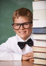 Boy kid, smile and portrait with books, classroom and learning for exam, assessment and studying for knowledge. Student Royalty Free Stock Photo