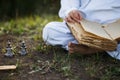 a boy in a kimono sits in a lotus position meditating in autumn, reading old book of wisdom