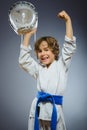 Boy in kimono during training karate exercises isolated on gray background Royalty Free Stock Photo