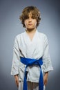 Boy in kimono during training karate exercises isolated on gray background Royalty Free Stock Photo