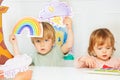 Boy in kindergarten show weather cards with storm and rainbow Royalty Free Stock Photo