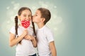 Boy kisses little girl with candy red lollipop in heart shape. Valentine`s day art portrait Royalty Free Stock Photo