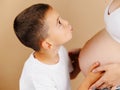 Boy kissing the belly of his mother. Royalty Free Stock Photo