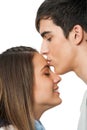 Boy kissing girlfriend on forehead.