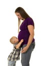 Boy kissing pregnant belly of mom in purple shirt Royalty Free Stock Photo