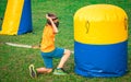 Boy kneeling in the grass to protect himself from enemies during archery tag