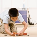 Boy kneeling and putting together parts of a mode