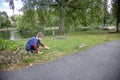 Boy by lake in Boston public garden reaching out to squirrel Royalty Free Stock Photo