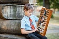 Boy with large abacus. Thoughtful schoolboy using a maths abacus calculation. Farewell Bell. day of knowledge. beginning of the