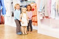 Boy and laughing girl stand with doll mannequin