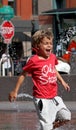 A boy laughing while playing amongst small fountains near Union Station in Denver on a very hot summer day