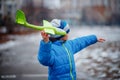 The boy launches a glider plane green in winter. Active games on the air. Airplane flights. Traveling in the winter Royalty Free Stock Photo